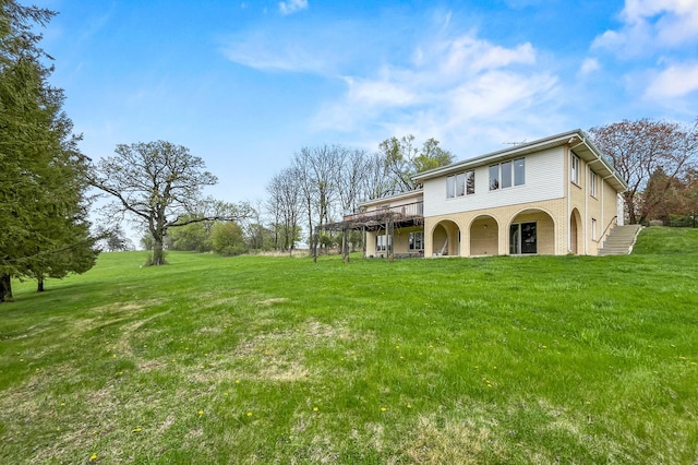 rear view of property with a yard, stairs, a deck, and brick siding