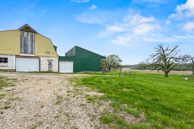 view of barn featuring a yard and driveway