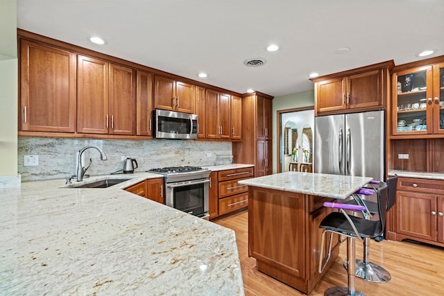 kitchen with appliances with stainless steel finishes, a sink, brown cabinets, and recessed lighting