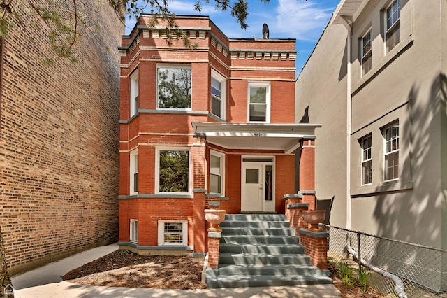 view of front of house with brick siding and fence