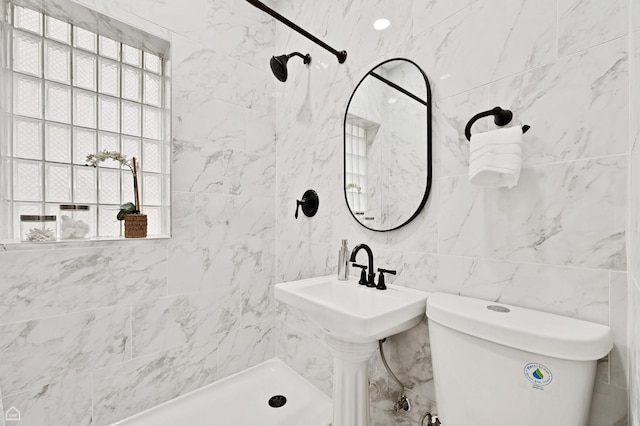 bathroom featuring tiled shower, toilet, and tile walls