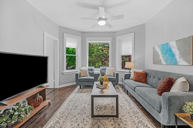 living area featuring wood finished floors, a ceiling fan, and baseboards