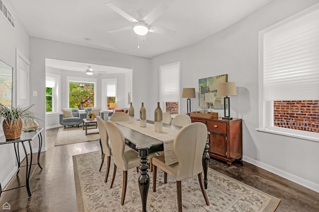 dining space with ceiling fan, baseboards, and dark wood-style floors