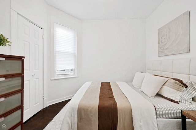 bedroom with dark wood-type flooring and baseboards