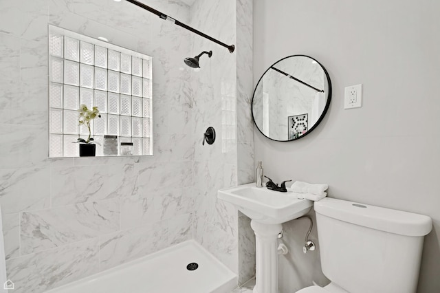 full bathroom featuring a tile shower and toilet