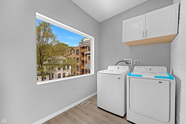 washroom with cabinet space, independent washer and dryer, light wood-style flooring, and baseboards