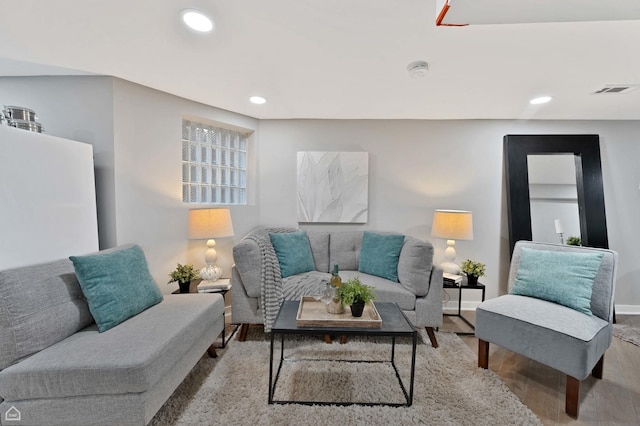 living area with wood finished floors, recessed lighting, and baseboards