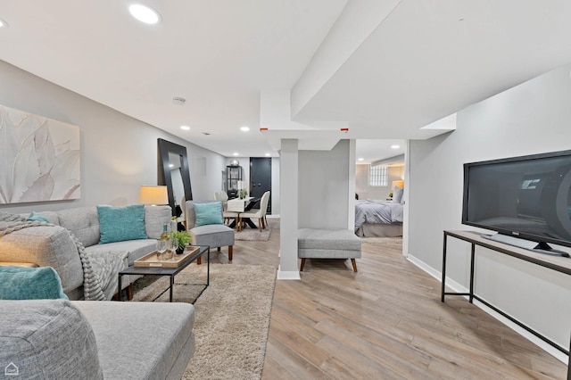 living area featuring light wood-style floors, baseboards, and recessed lighting