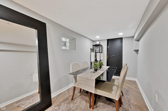 dining room with light wood finished floors, baseboards, and recessed lighting