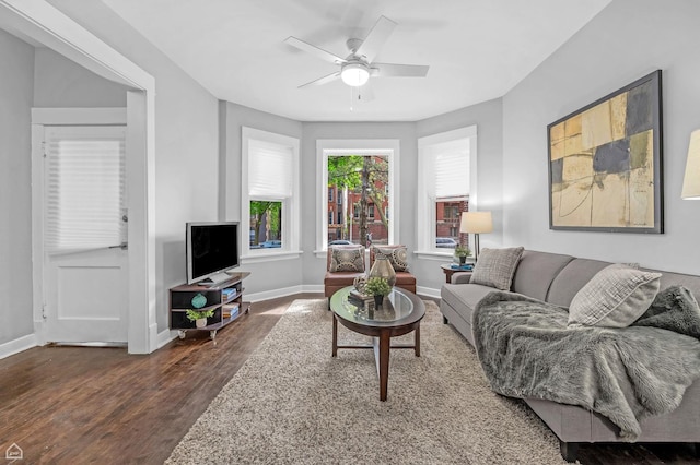 living room featuring wood finished floors, baseboards, and ceiling fan