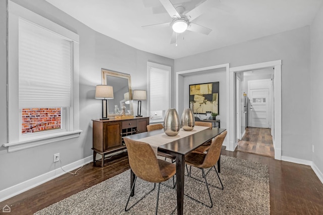 dining space featuring wood finished floors, baseboards, and a ceiling fan