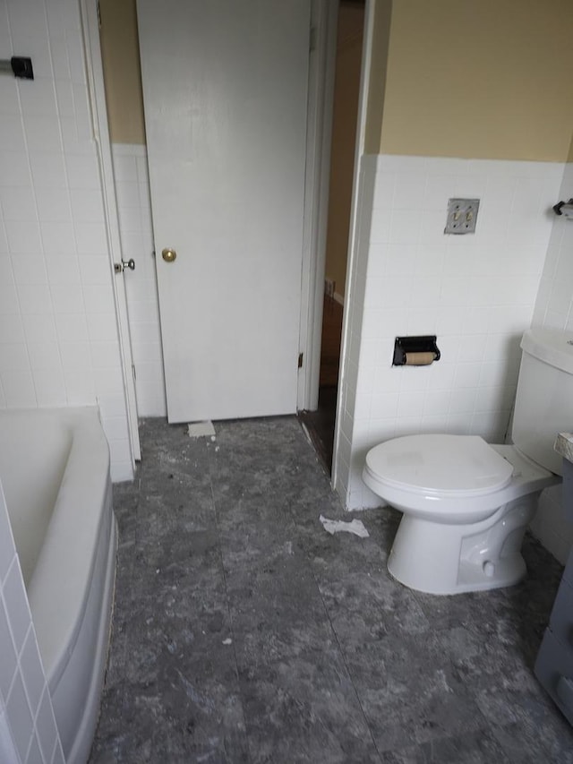 656 E 160th Pl, South Holland, IL 60473 - bathroom featuring toilet, tile walls, a bath, and a wainscoted wall