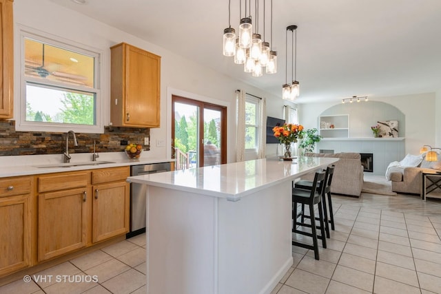 129 S Palmer Dr, Bolingbrook, IL 60490 - kitchen with stainless steel dishwasher, a sink, light tile patterned floors, open floor plan, and a kitchen bar