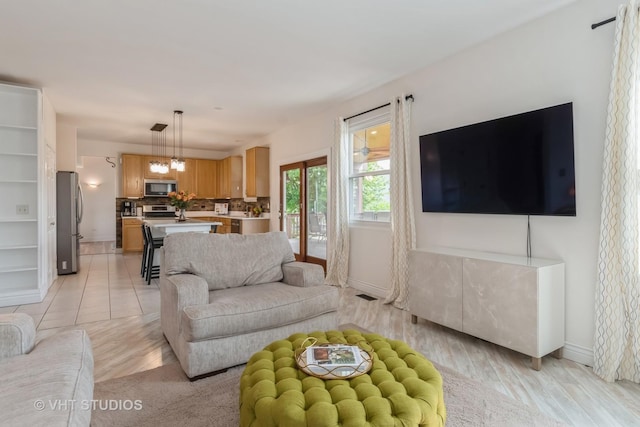 129 S Palmer Dr, Bolingbrook, IL 60490 - living area with baseboards, light wood-style flooring, and a chandelier