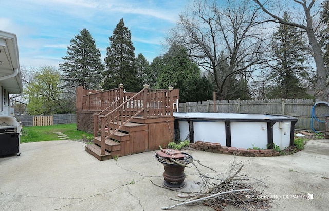 view of patio with a fenced backyard, a swimming pool, a deck, and area for grilling