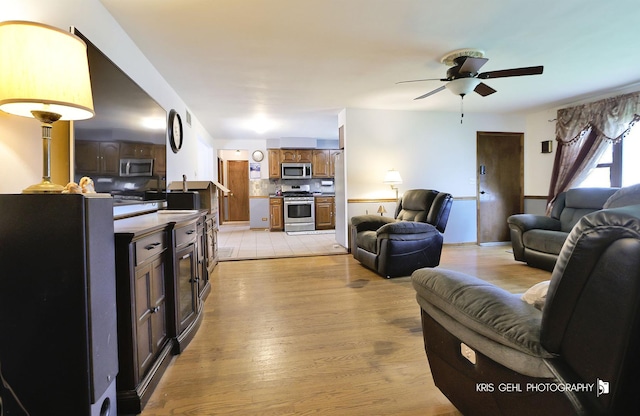 living room with ceiling fan and light wood-type flooring