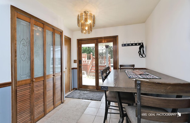 doorway to outside with light tile patterned floors and a chandelier