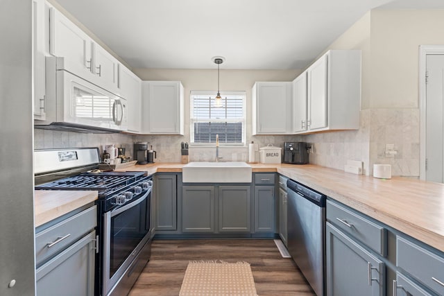 711 W Benham St, Kirkland, IL 60146 - kitchen featuring appliances with stainless steel finishes, dark wood-style flooring, decorative backsplash, and white cabinets