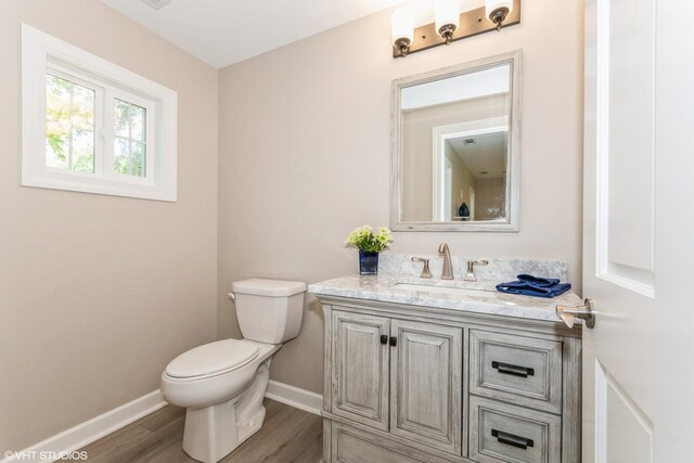 34327 S Lakeside Ter, Wilmington, IL 60481 - half bathroom featuring toilet, baseboards, wood finished floors, and vanity