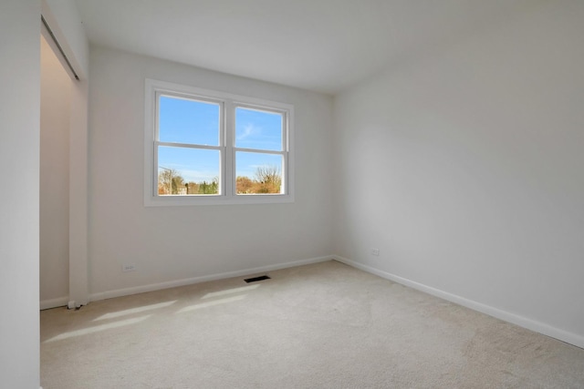 carpeted spare room with baseboards and visible vents