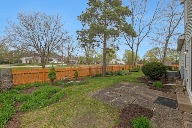 view of yard featuring fence, central air condition unit, and a patio area