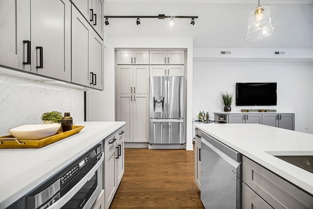kitchen with gray cabinets, decorative light fixtures, visible vents, dark wood finished floors, and stainless steel appliances