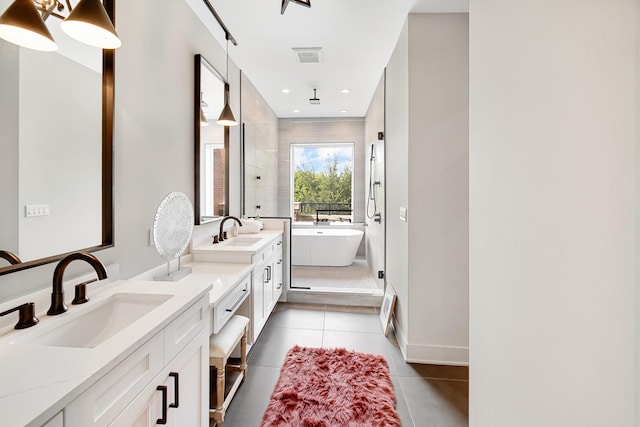 bathroom featuring double vanity, a sink, tile patterned floors, a soaking tub, and tiled shower