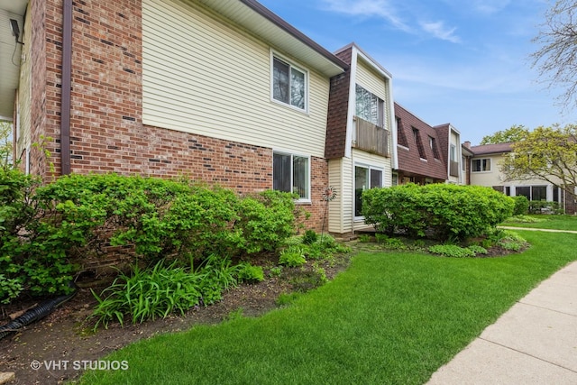 3026 Roberts Dr Unit 4, Woodridge, IL 60517 - view of front facade featuring a shingled roof, a front lawn, brick siding, and mansard roof