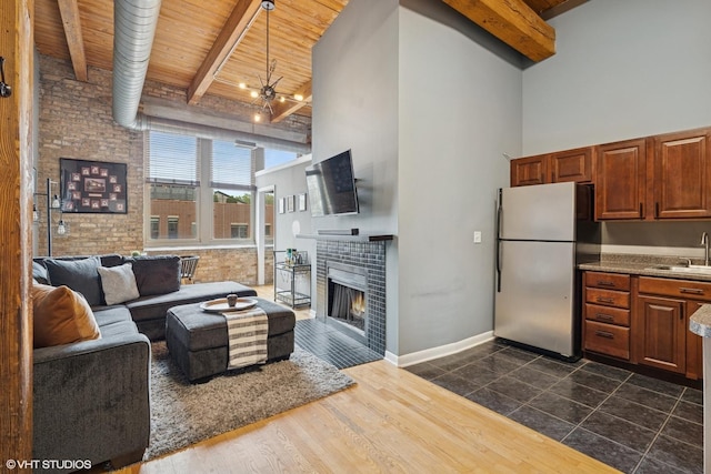 living room featuring beam ceiling, wood ceiling, and a towering ceiling