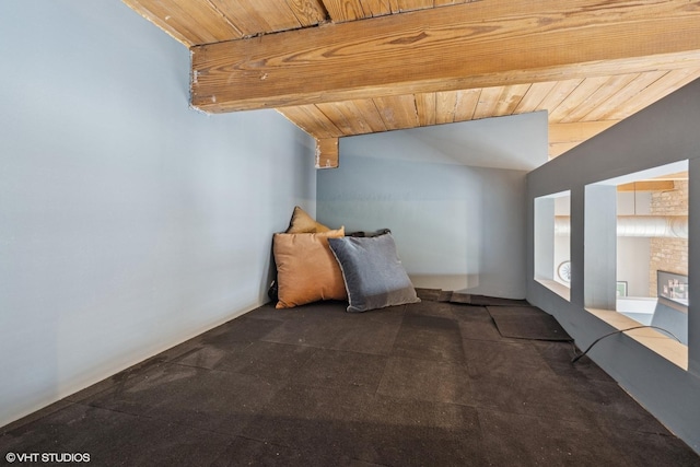 unfurnished bedroom with carpet flooring, lofted ceiling with beams, and wood ceiling