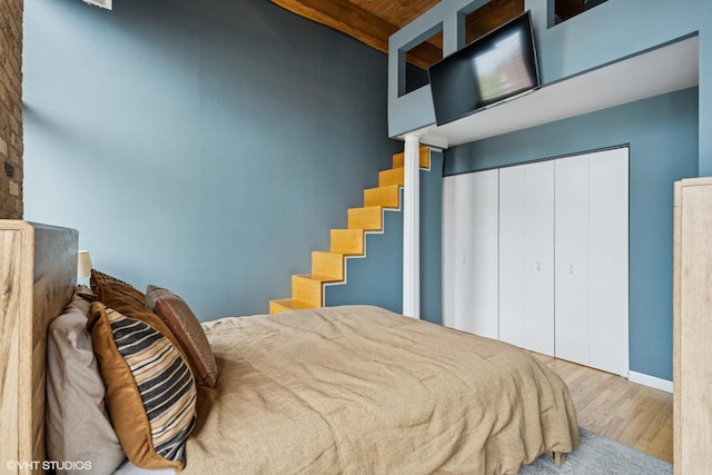 bedroom featuring baseboards, a closet, and wood finished floors