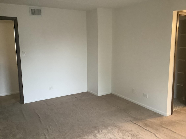 carpeted empty room with visible vents and baseboards