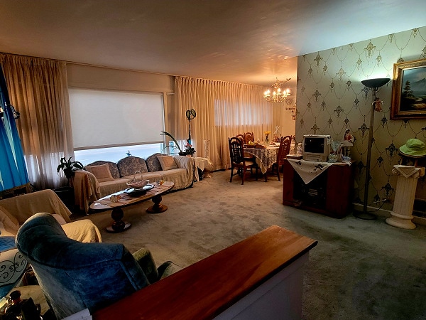 3843 Dempster St, Skokie, IL 60076 - carpeted living room featuring a notable chandelier and wallpapered walls