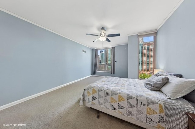 carpeted bedroom featuring crown molding, baseboards, and a ceiling fan