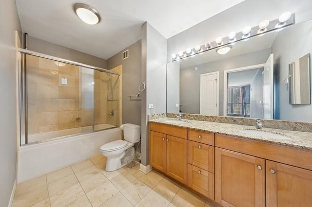 bathroom featuring toilet, double vanity, and shower / bath combination with glass door