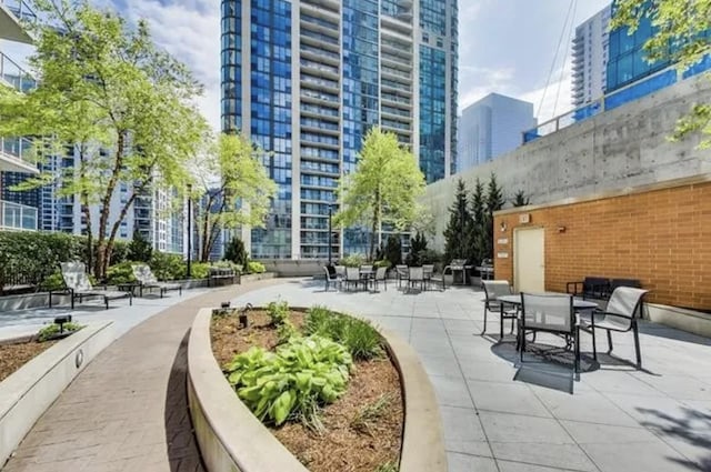 view of property's community with a view of city, a patio area, and outdoor dining space