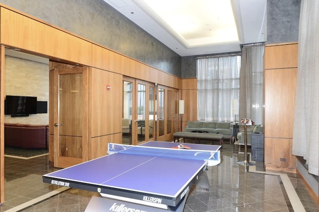 playroom featuring granite tiled floors, french doors, and a high ceiling
