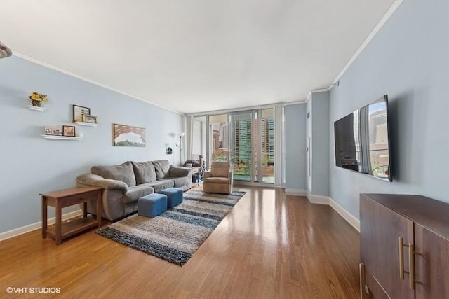 living area with crown molding, wood finished floors, baseboards, and floor to ceiling windows
