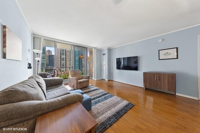 living room with crown molding, wood finished floors, floor to ceiling windows, and baseboards