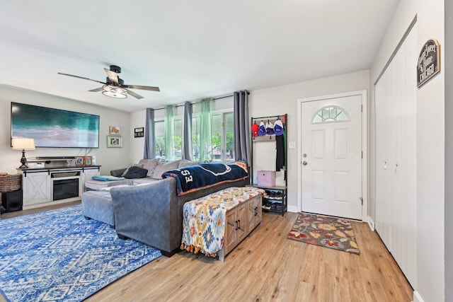living room featuring light wood-style floors and a ceiling fan