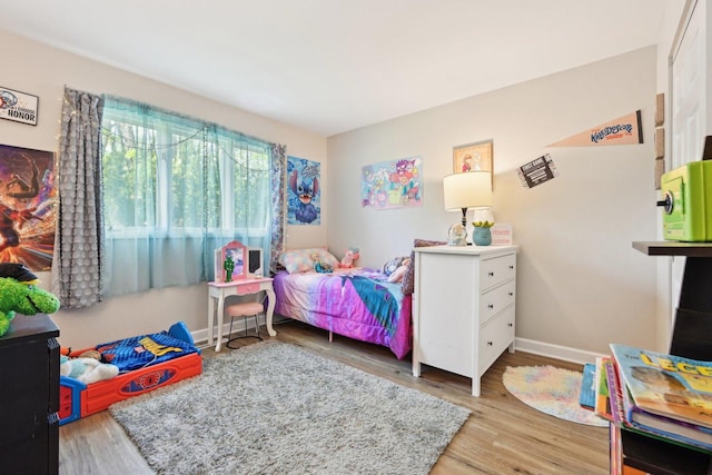 bedroom featuring wood finished floors and baseboards