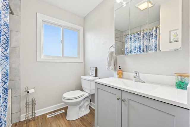 full bath featuring baseboards, wood finished floors, toilet, a shower with curtain, and vanity