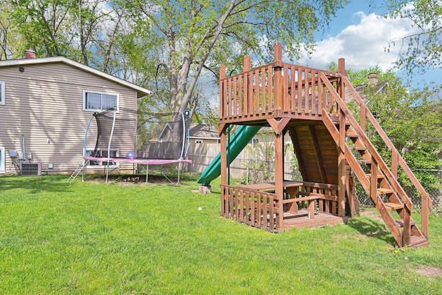 view of yard with a trampoline, a wooden deck, and central AC