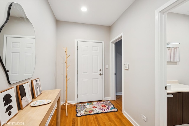 foyer entrance featuring light wood-style floors, recessed lighting, and baseboards