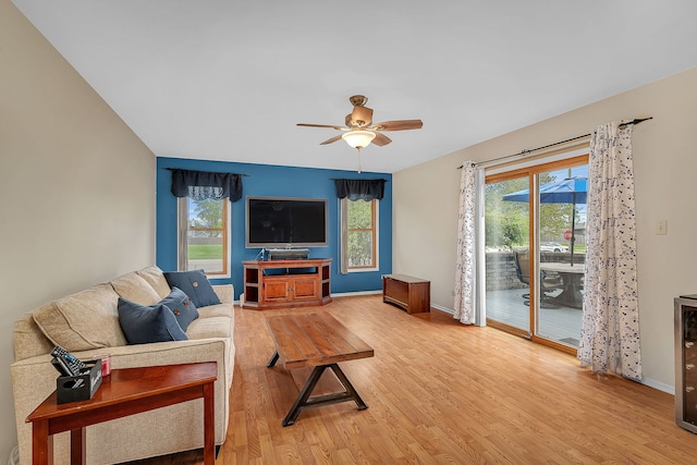 living room featuring baseboards, light wood finished floors, and ceiling fan
