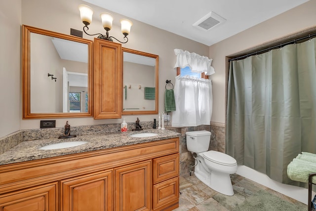 bathroom with double vanity, toilet, tile walls, and a sink