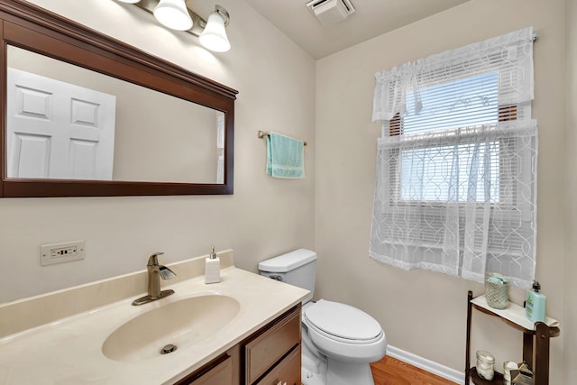 bathroom with visible vents, wood finished floors, toilet, and vanity