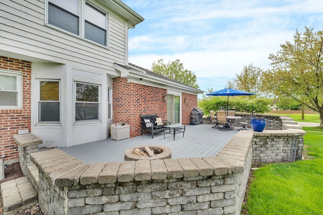view of patio with a wooden deck, a fire pit, and outdoor dining space