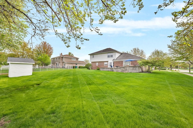 view of yard featuring fence, an outbuilding, and a storage shed