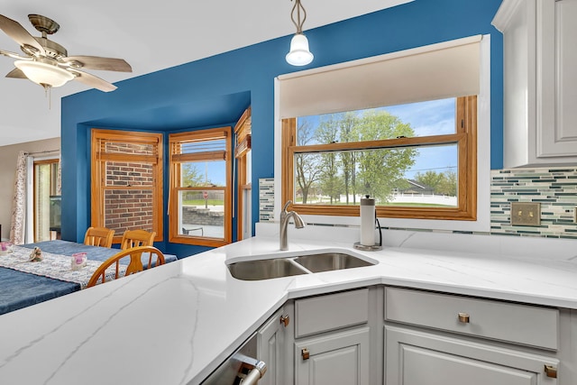 kitchen with a sink, tasteful backsplash, a ceiling fan, and a wealth of natural light
